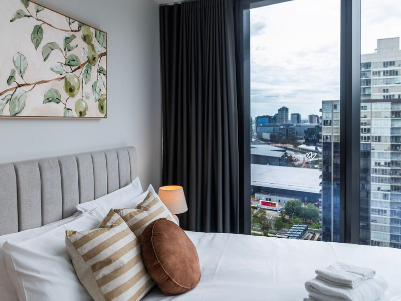 Serene bedroom corner showcasing artwork and plush bedding.