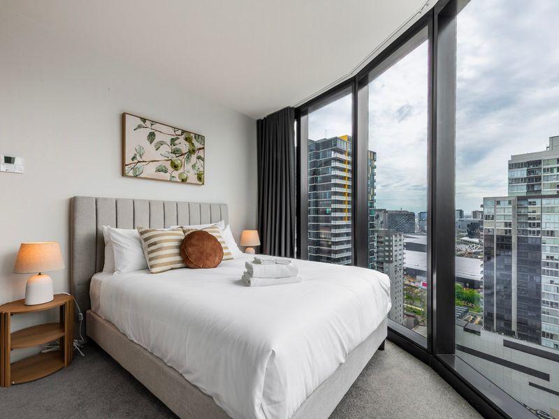 Queen bedroom featuring full-height windows and abundant natural light.