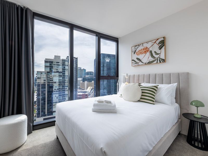 Second bedroom styled for comfort with sweeping urban views.