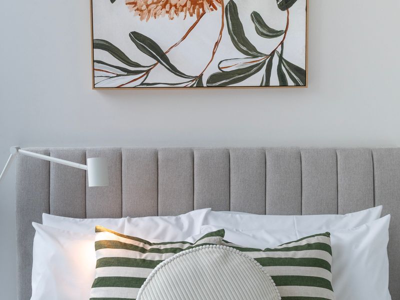 Soft, neutral bedroom styling with premium headboard and linens.