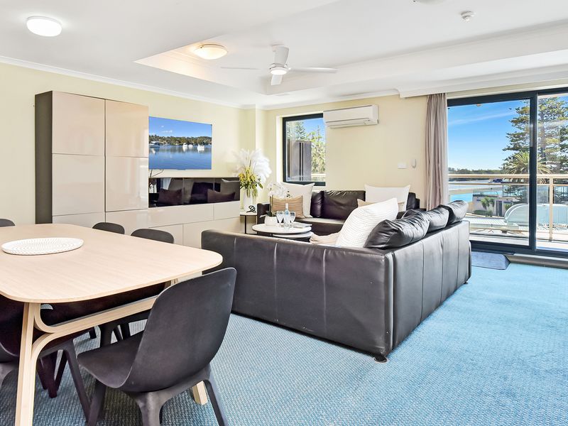 Bright open-plan living and dining area with comfortable seating and beautiful water views.