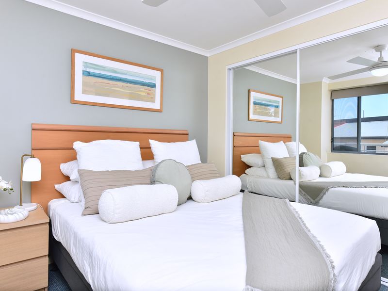 Inviting bedroom with mirrored wardrobe and natural light