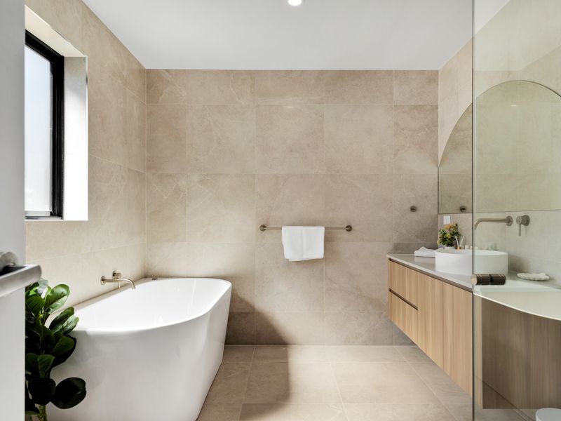 Elegant bathroom with soaking tub and warm finishes