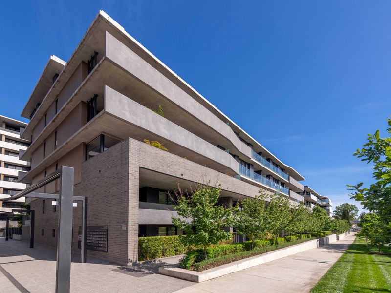 Modern apartment exterior with lush landscaping and clean architectural lines.