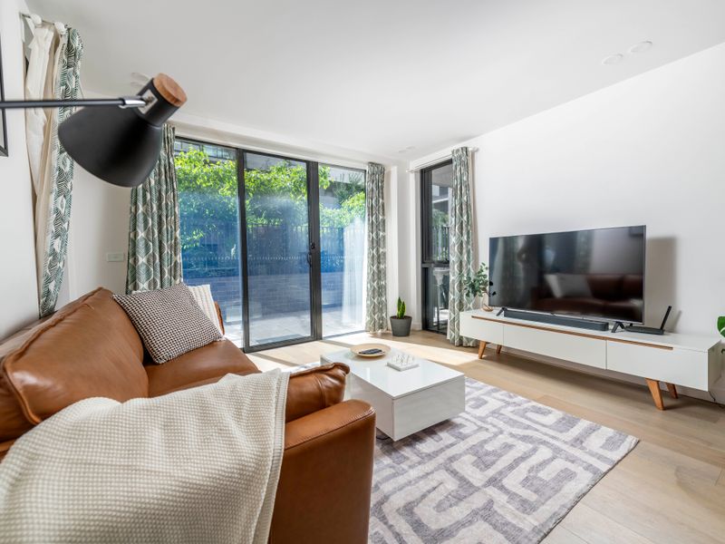 Stylish living room with plenty of natural light and leafy views.