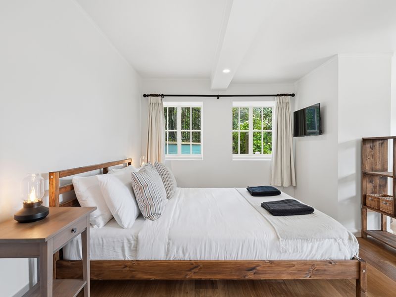 Airy bedroom with TV and garden views.