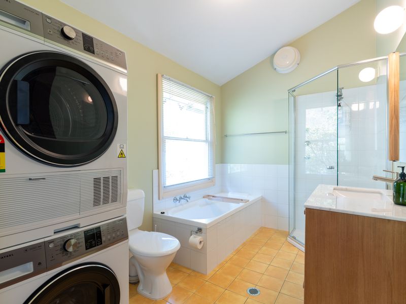 Bathroom with washer, dryer, and walk-in shower.