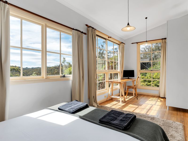 Sun-filled master bedroom with spacious layout and seating nook with views of the National Park