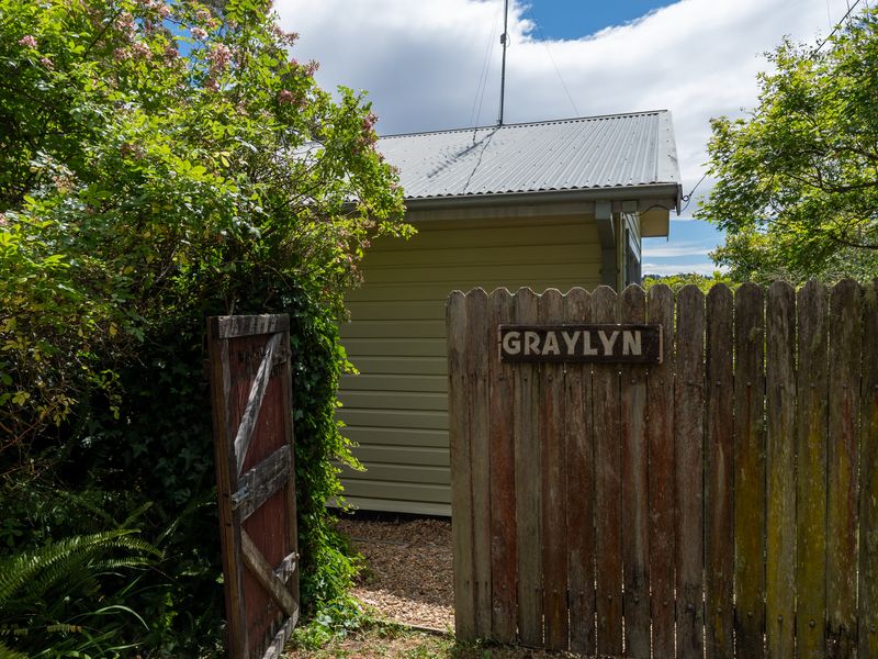 Inviting garden gate entrance marked with rustic signage.