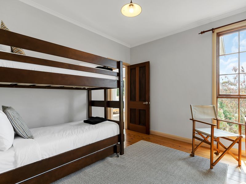Light-filled bunk room with warm wooden accents.