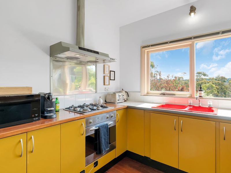 Bright kitchen with large windows and retro-style cabinetry.