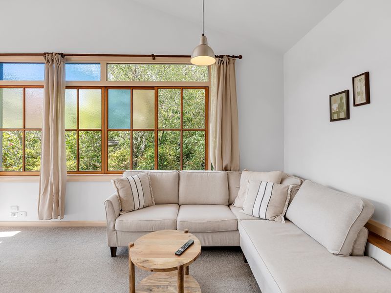 Comfortable living room with large windows and garden views.