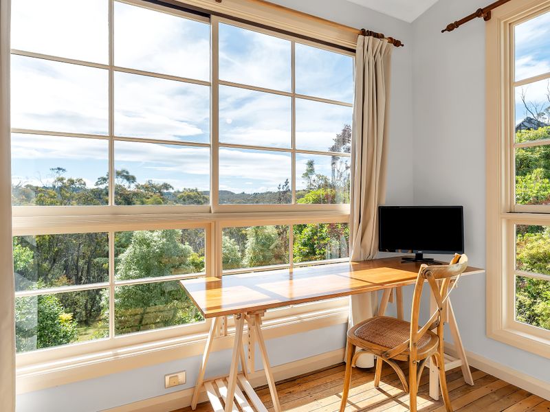 Relaxed work or dining space with expansive treetop scenery.