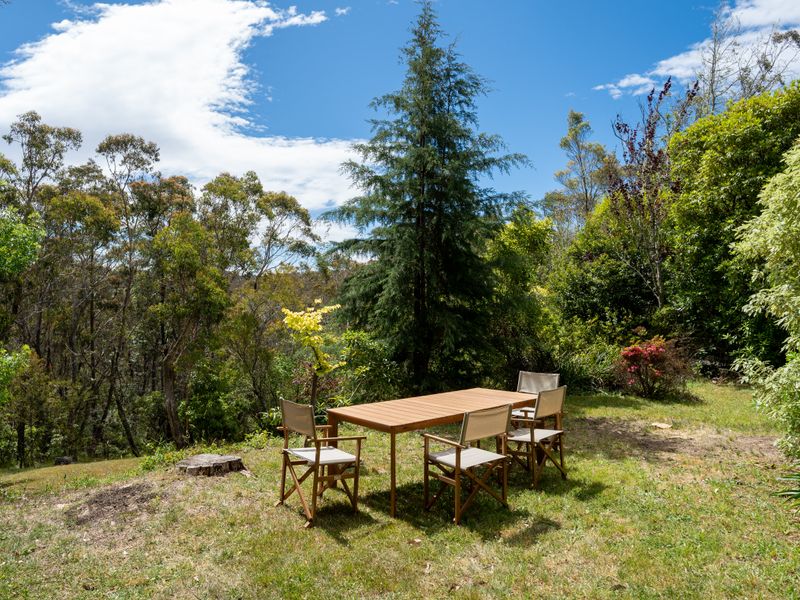 Secluded outdoor dining area surrounded by native greenery.