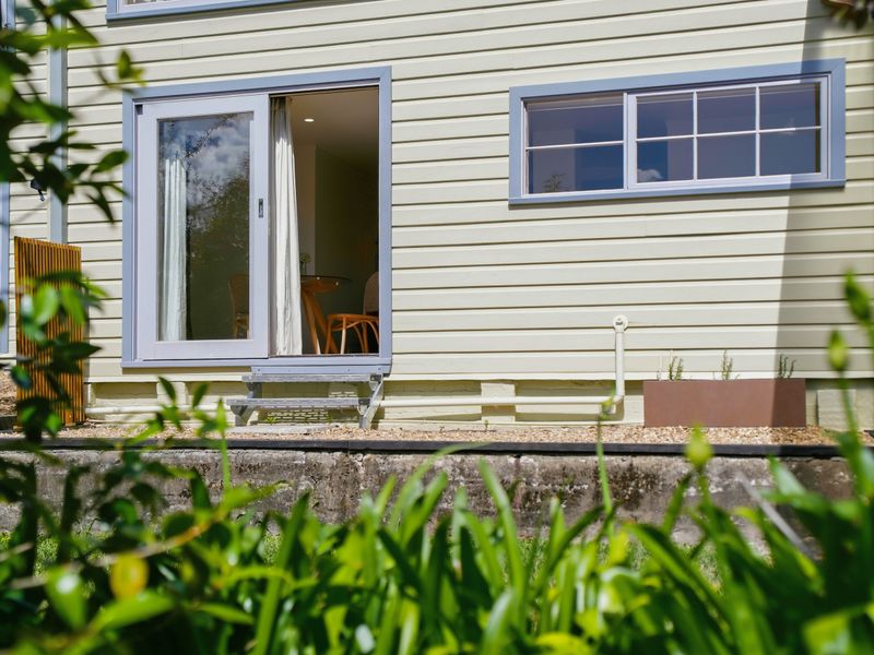 Side view of the home featuring peaceful leafy surroundings.