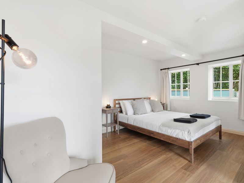 Spacious bedroom with a comfortable queen bed and natural light.