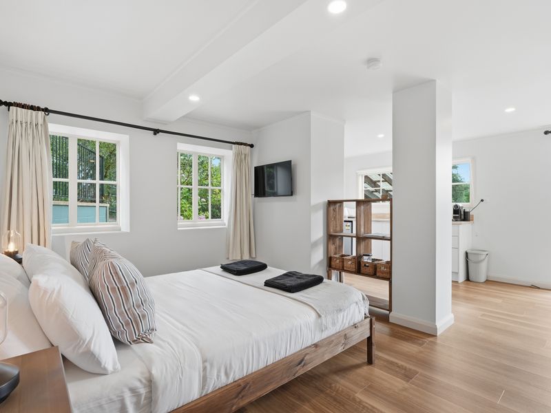 Airy bedroom with TV and garden views.