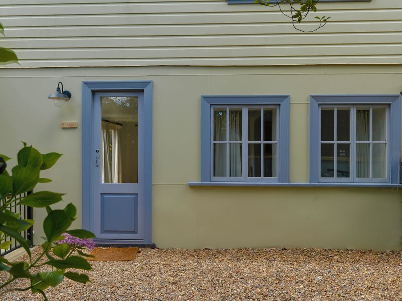 Classic cottage-style entrance with pastel accents and a welcoming vibe.