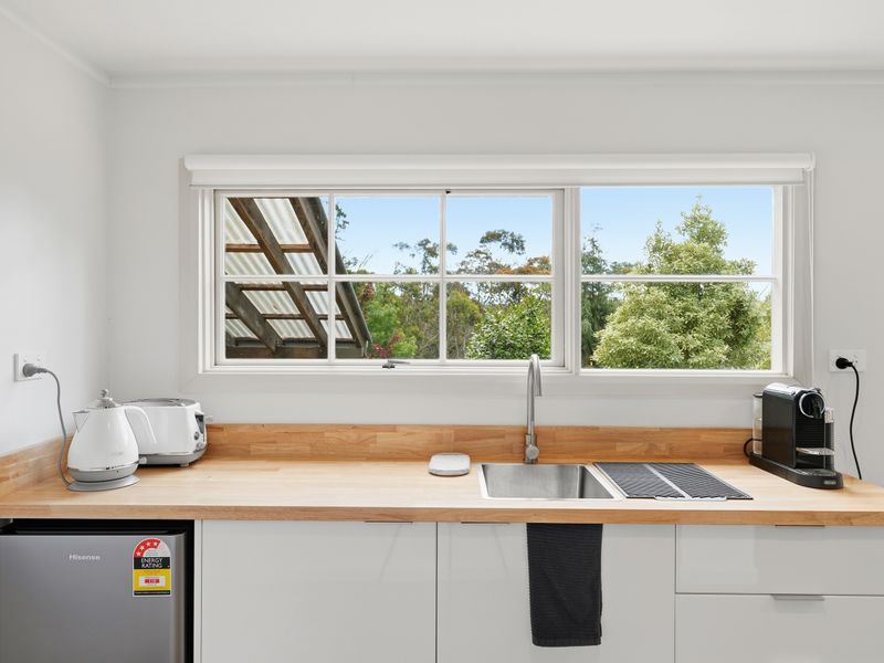 Full kitchen setup featuring appliances, sink, and garden views.