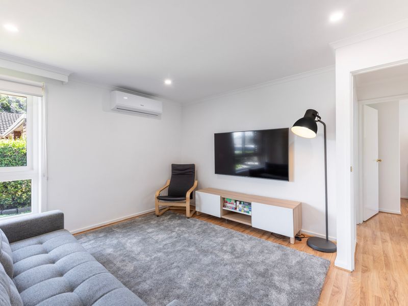 Spacious living area with plush sofa and TV