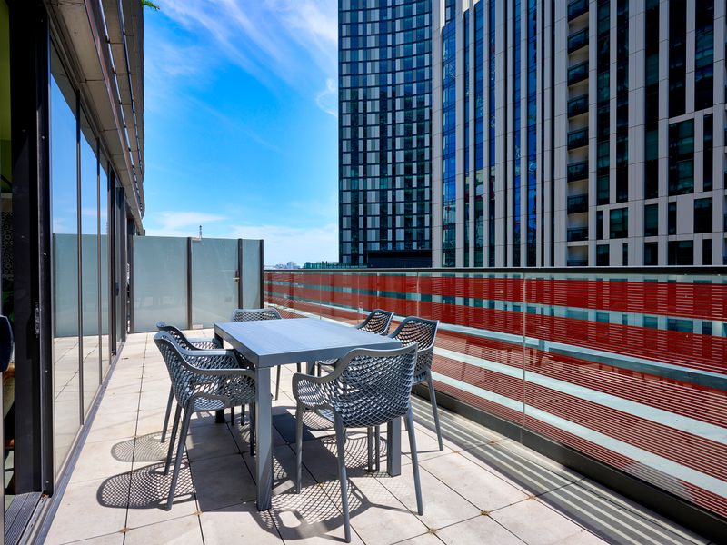 Private balcony with outdoor dining set and open city views.