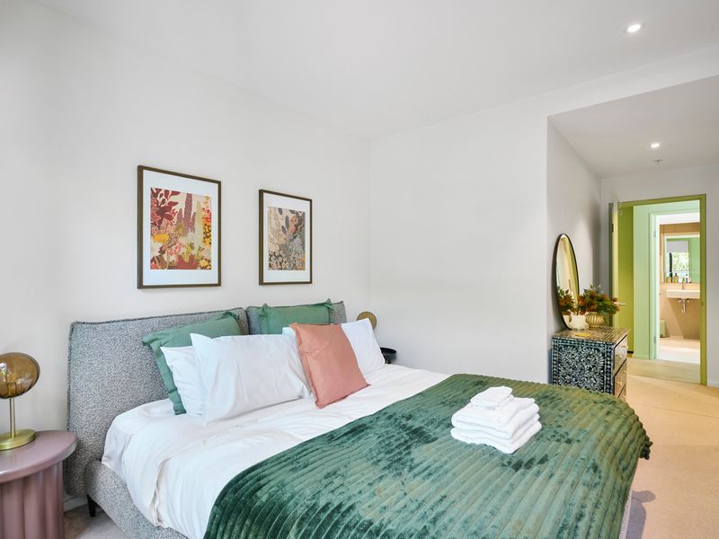 Bedroom styled with layered bedding and framed artwork.