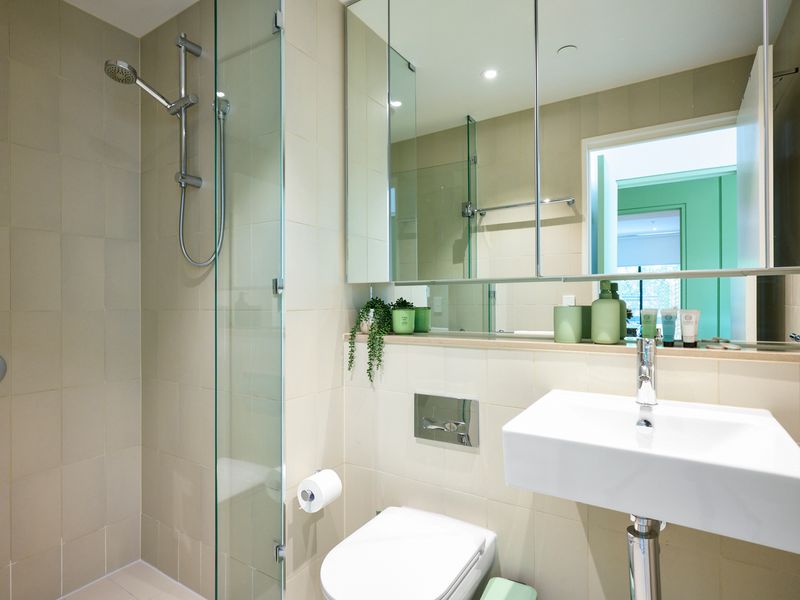 Modern bathroom with glass shower, sleek fixtures, and fresh towels.