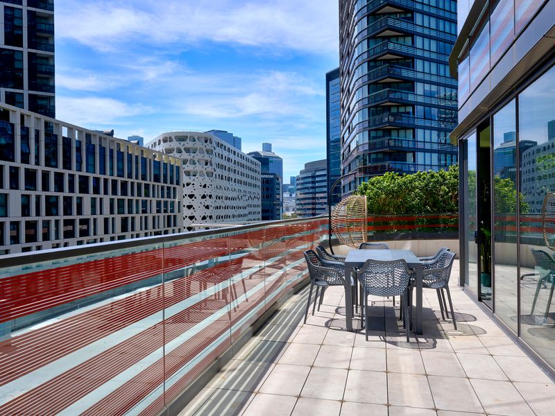Expansive private balcony with outdoor seating and stunning city views.