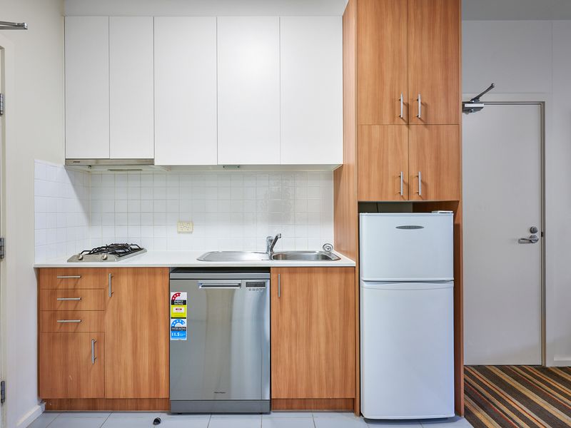 Compact kitchen with fridge, stove, and ample storage