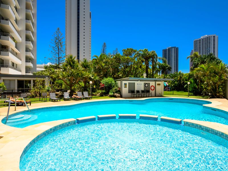Resort-style pool with sun loungers and tower views.