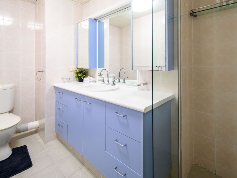 Spacious bathroom with large vanity and mirror.