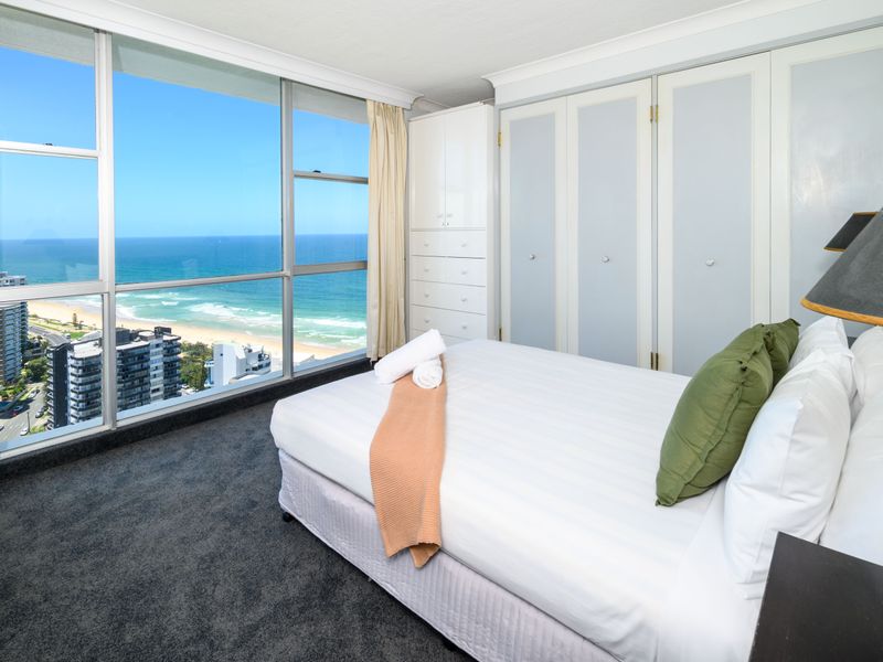 Bedroom with stunning ocean views from floor-to-ceiling windows.