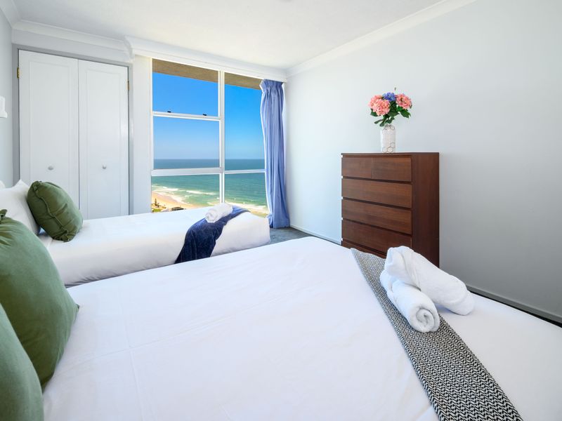 Light-filled bedroom featuring a cozy queen bed.