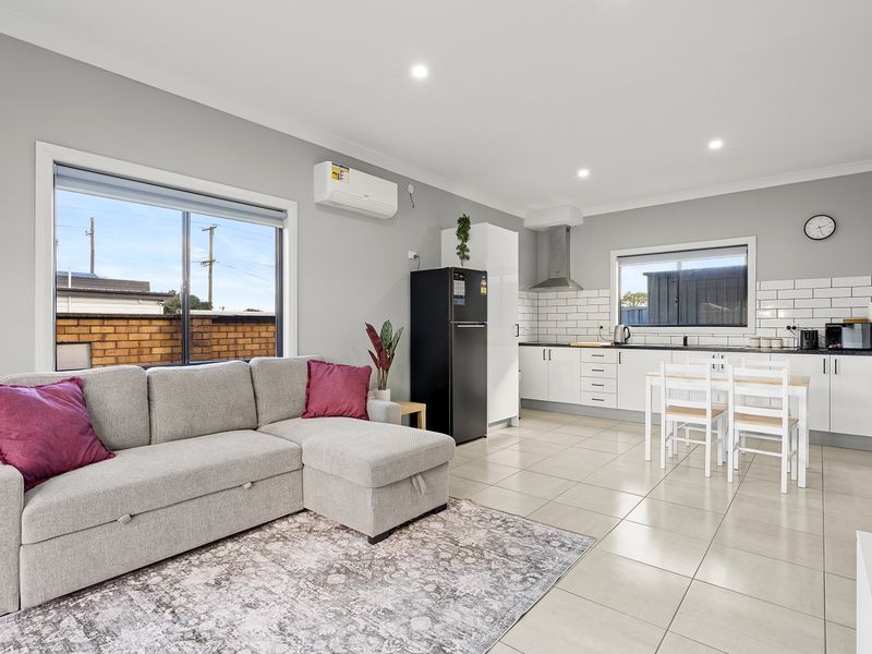 Spacious living area with comfortable seating, smart TV and plenty of natural light.