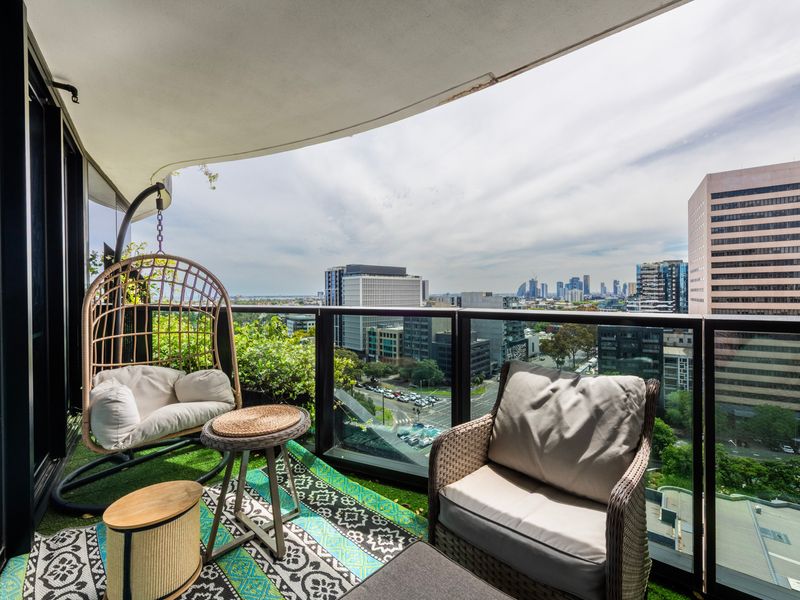Private balcony lounge with city views and cosy seating.