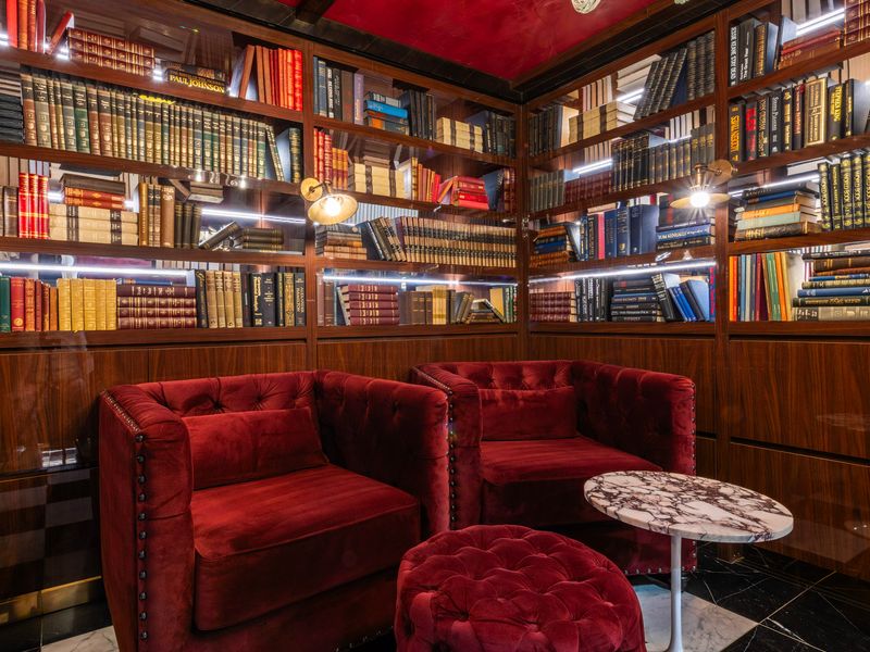 Cozy reading corner surrounded by floor-to-ceiling bookshelves.