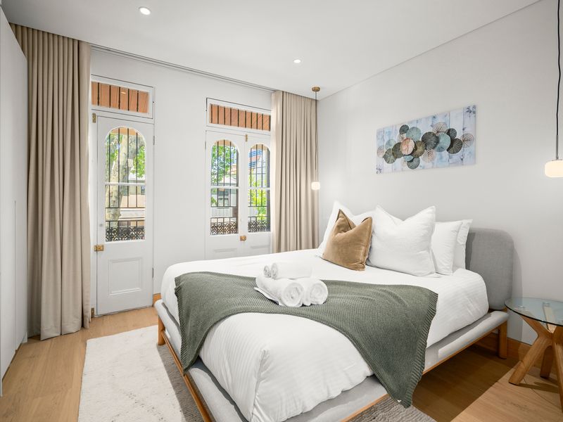 Main bedroom with queen bed and large windows