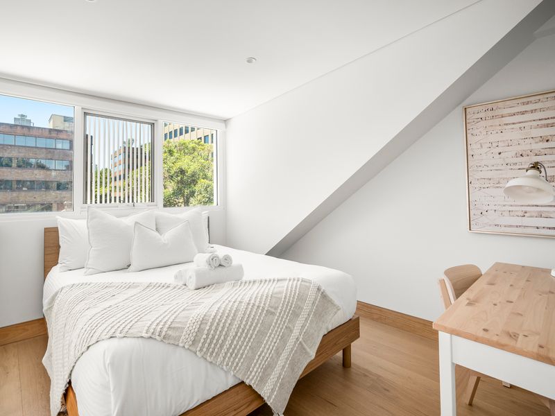 Top-floor bedroom with skylight, desk, and city views