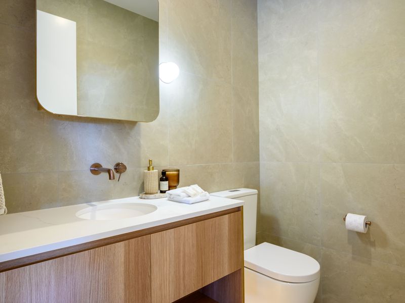Minimalist bathroom with modern vanity and warm tones.