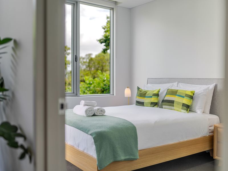 Peaceful bedroom with soft linens and greenery views