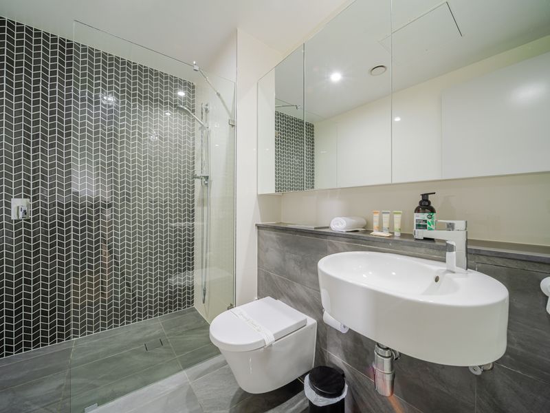 Bright bathroom featuring a rain shower and elegant tiling