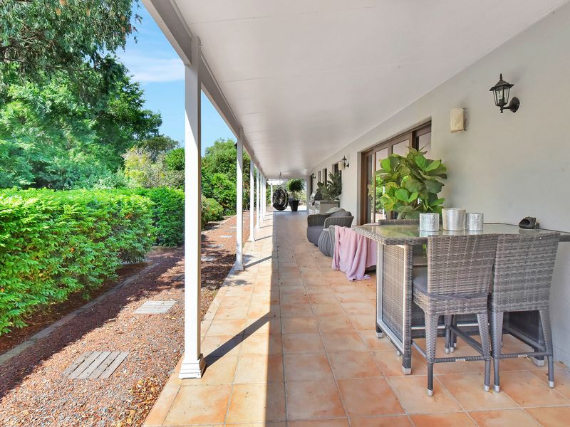 Covered outdoor dining area overlooking a peaceful garden path