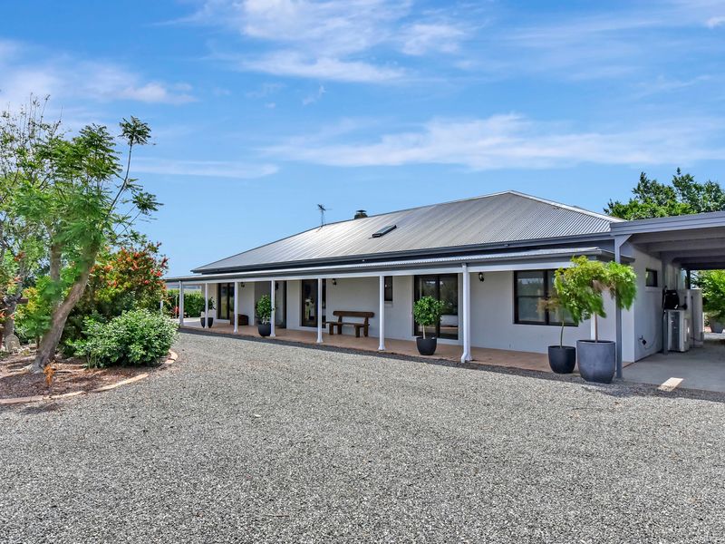 Wide exterior view of the home with neat landscaping and open yard