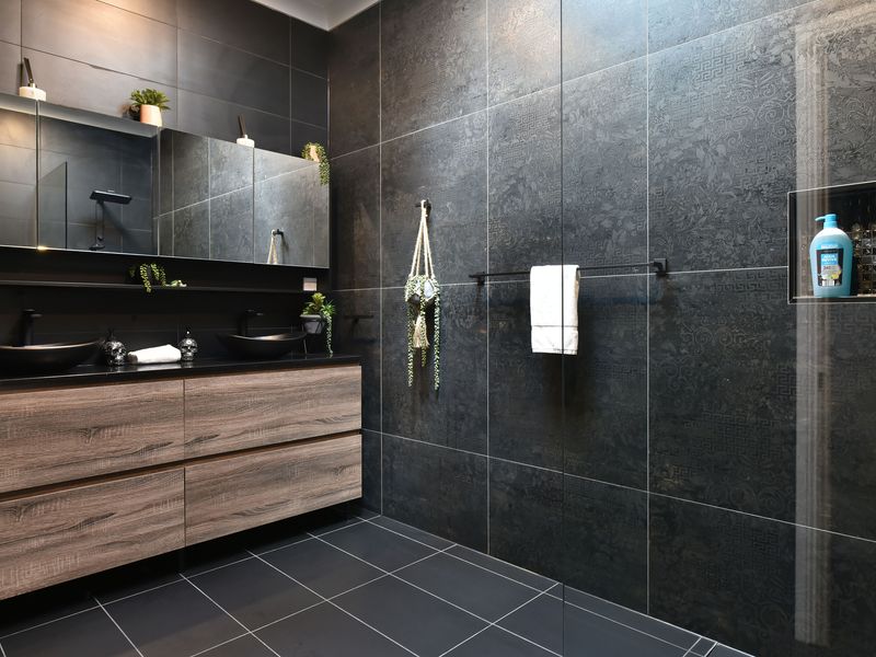 Stylish double-vanity bathroom with contemporary dark tiling