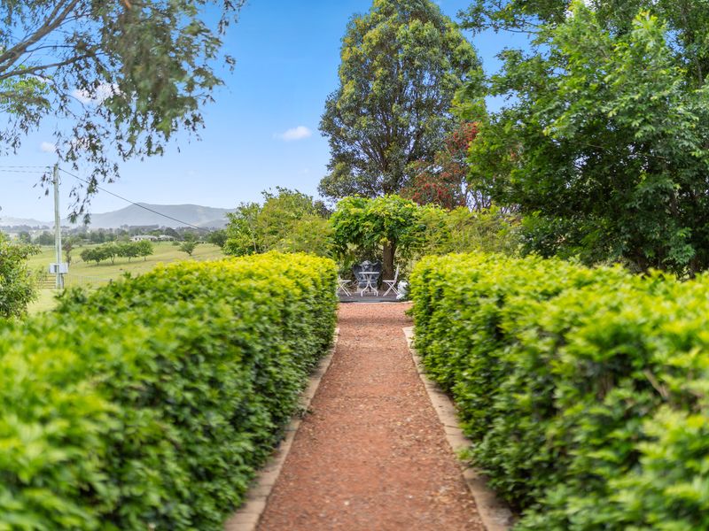 Garden pathway surrounded by lush hedges and country charm