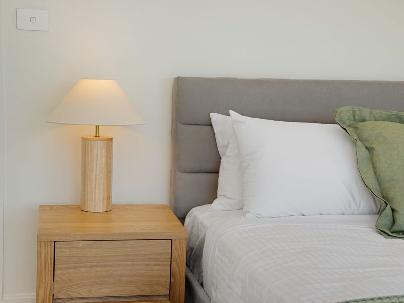 Comfortable bed with fresh linens and bedside lighting