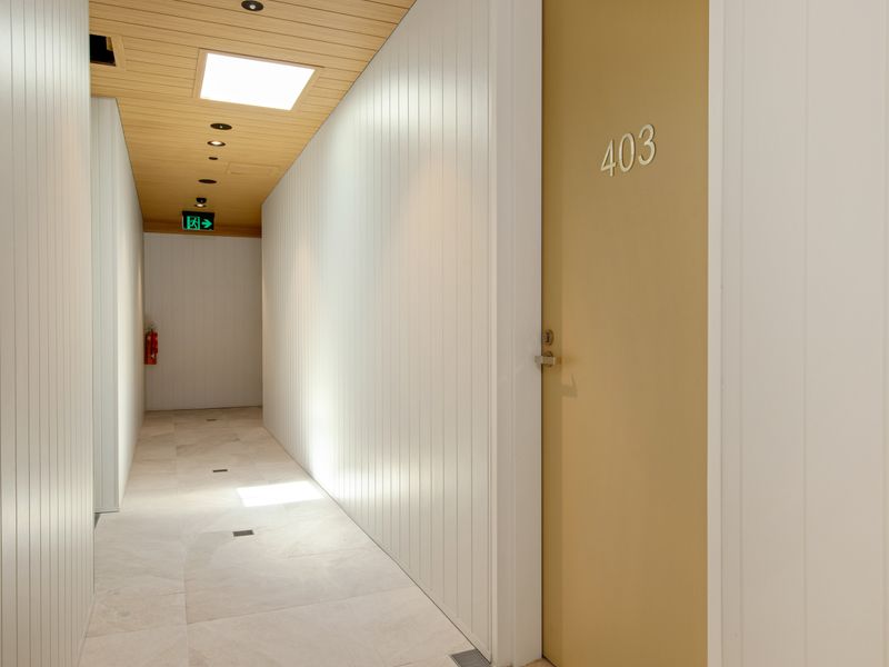Quiet, well-lit hallway leading to the apartment