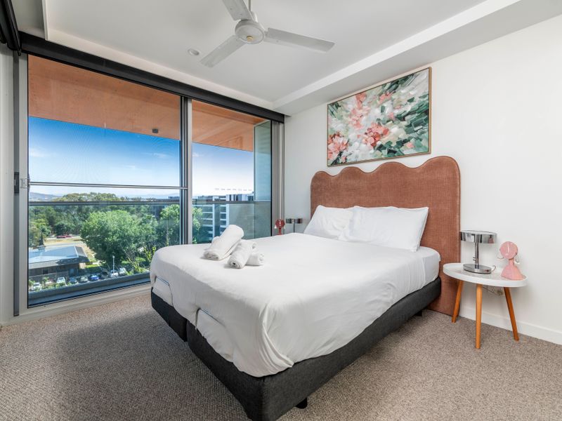 Bedroom view opening onto the balcony and treetop scenery