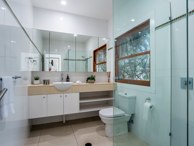 The secondary bathroom features a cohesive design that mirrors the modern, spa-like aesthetic found throughout the home.