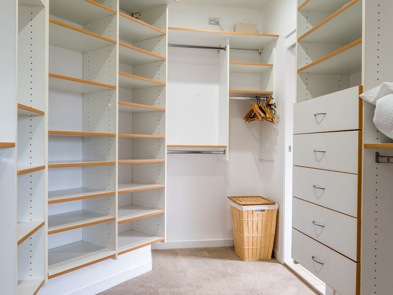 Features a dedicated wall of open shelving for shoes or folded items and multiple tiers of hanging space.